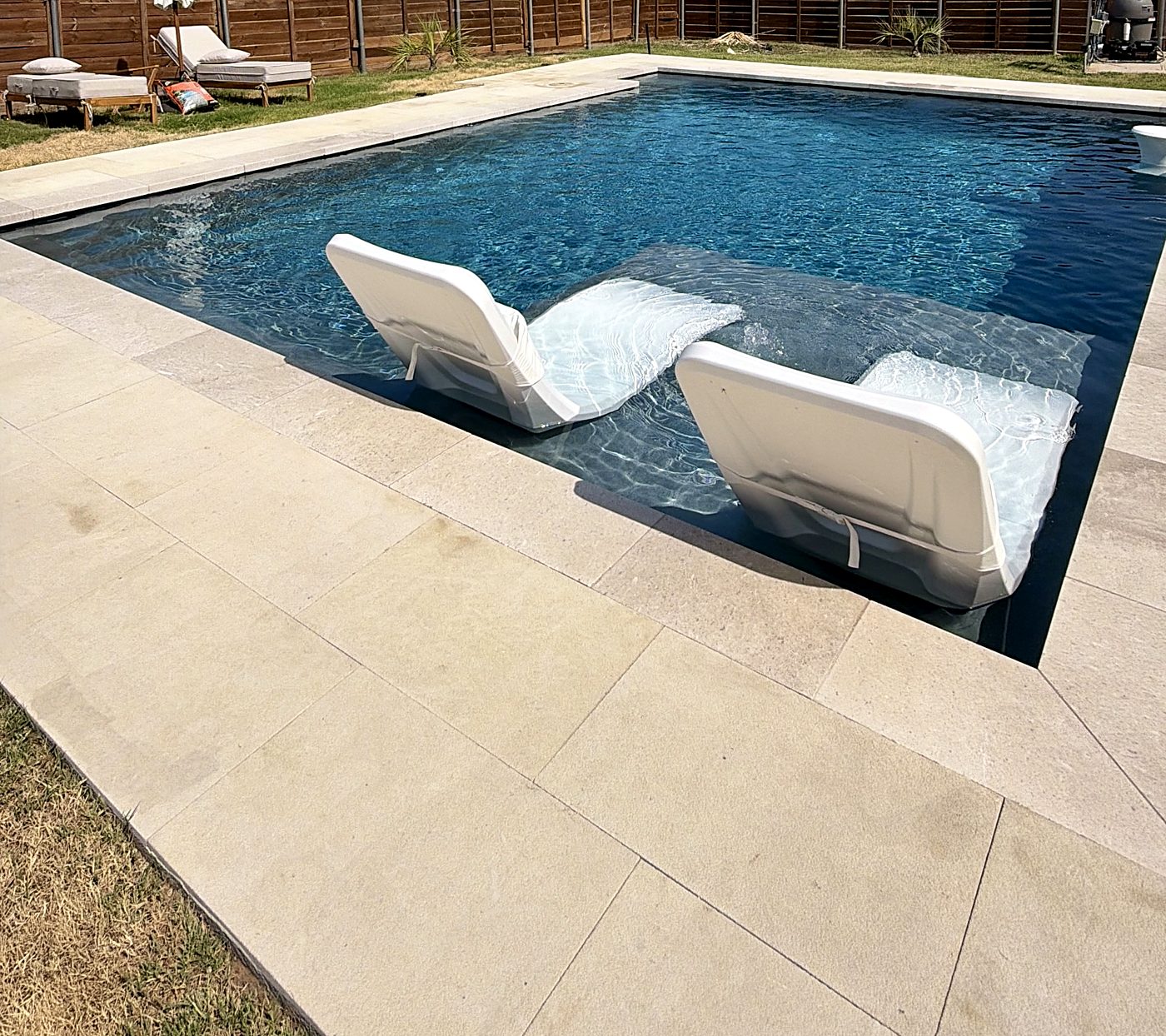 Two in-water loungers on a tanning ledge